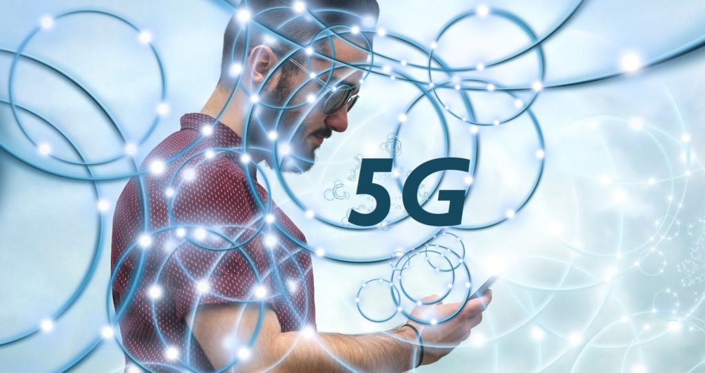 Homme qui regarde son smartphone avec un réseau tout autour de lui et l'inscription "5G"