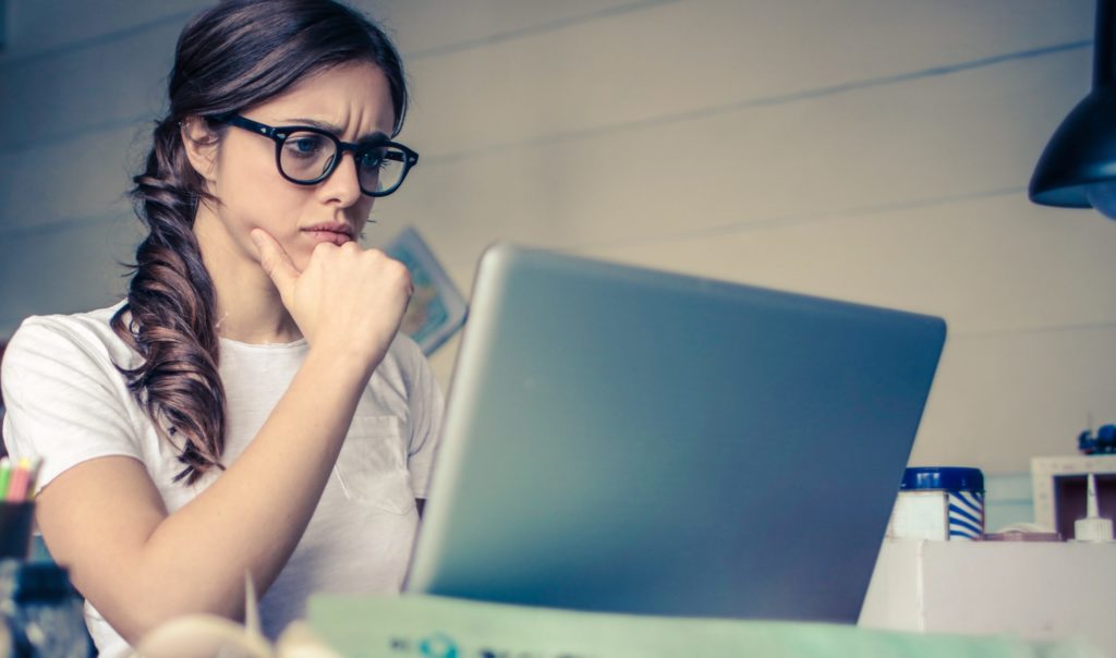 femme qui regarde de manière sceptique sur l'écran