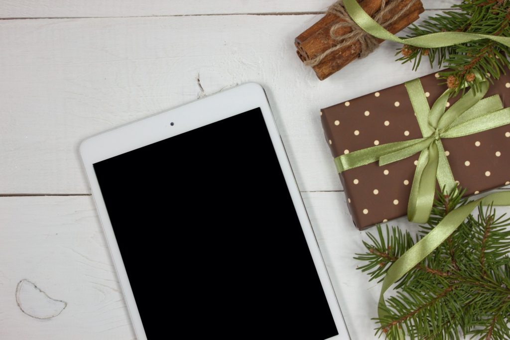 Foto eines iPad auf einem Tisch neben einem Weihnachtsgeschenk platziert