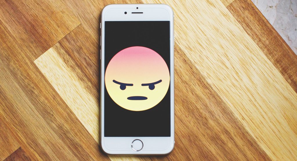 Smartphone Bildschirm mit einem großen wütendem emoji auf dem Bildschirm