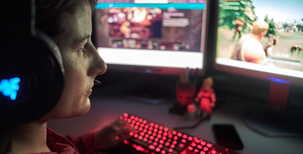 Jeune fille devant son ordinateur en train de regarder un stream de jeu vidéo