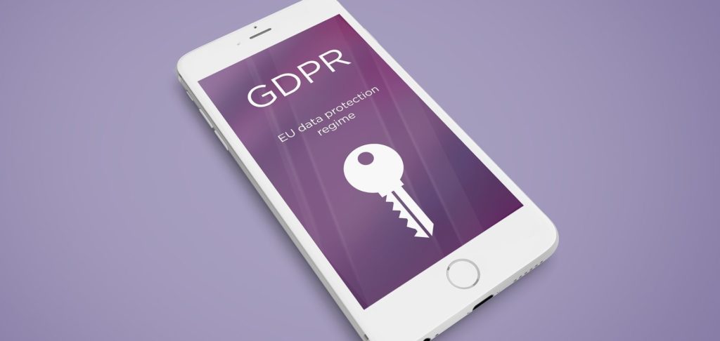 Photo d'un smartphone avec en fond d'écran l'inscription "GDPR, EU protection data regime" et une clé