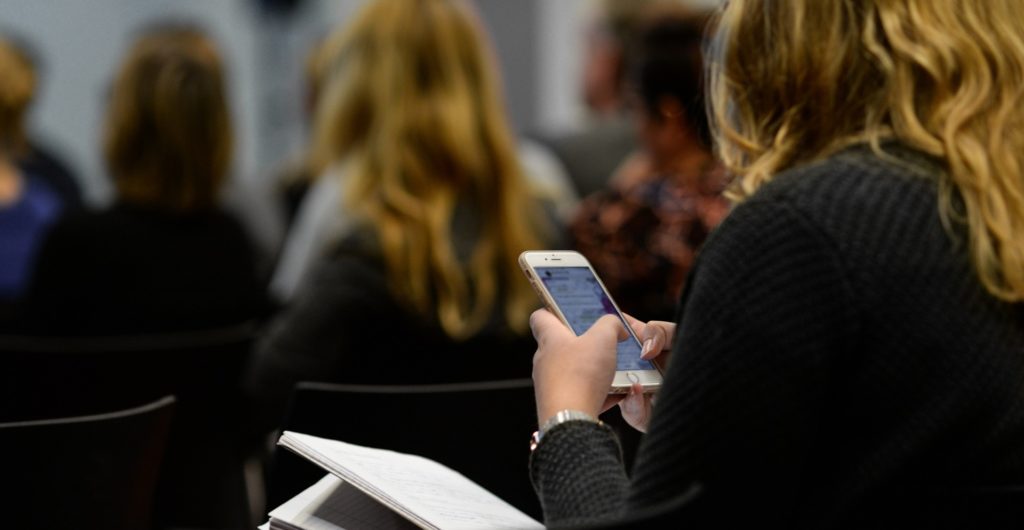 Jeune fille utilisant son téléphone portable en classe