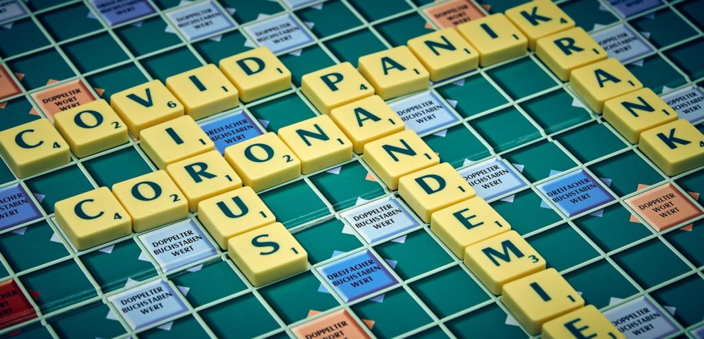 scrabble-covid19 Plateau du jeu "Scrabble" avec des mots comme : pandémie, coronavirus, panique