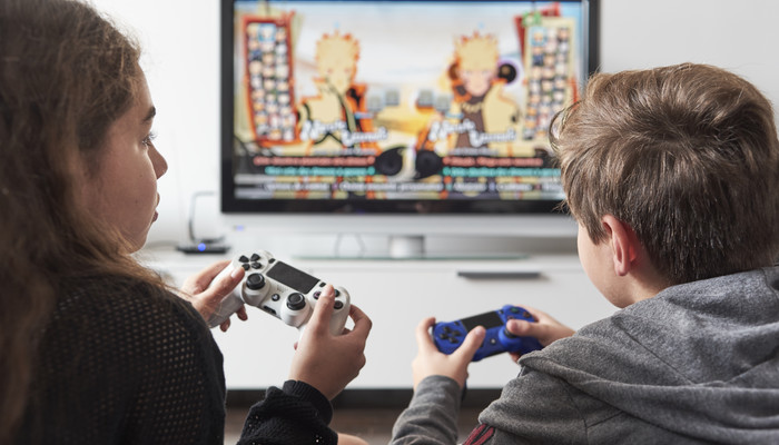Deux adolescents jouent à une console de jeu
