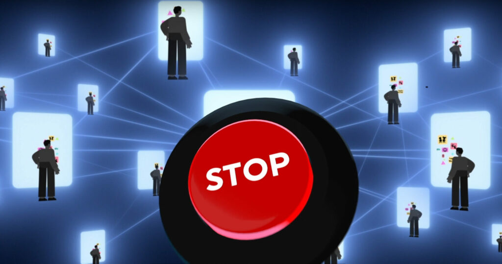 Bild mit Personen vor einem Bildschirm, die miteinander verbunden sind und einem großen STOP-Knopf in der Mitte.